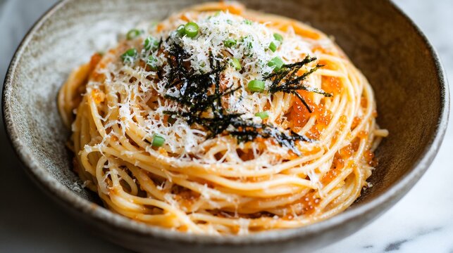 Japanese mentaiko spaghetti spicy cod roe garnished with shredded nori and green onions served in a rustic bowl