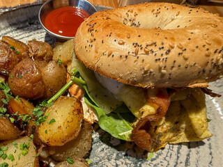 Bagel Breakfast Sandwich With Fried Potatoes And Ketchup
