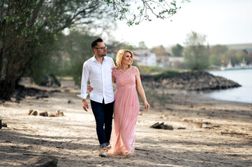 Couple in love walking on the beach, happy pair on beach, photo of the young family, woman in long...