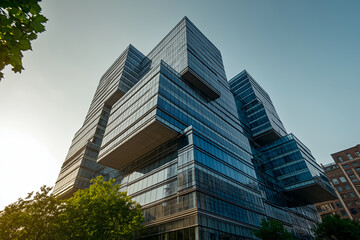 Obraz premium Modern glass architecture with stacked geometric design reflecting sunlight and city skyline in urban landscape
