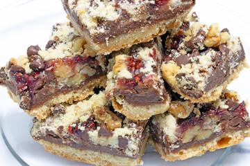 Bittersweet dark chocolate raspberry dessert bars with chopped walnuts on bottom layer of butter, flour and brown sugar