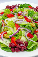 Vegetarian, Mediterranean dinner plate with lettuce, peppers, celery, olives, beets, pistachios, onion and cucumber