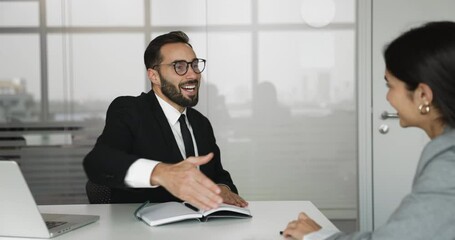 Hispanic businessman shake hands with woman colleague or client start or finish formal meeting in office, reached understanding or finalized terms on deal, project or partnership. Business, conclusion