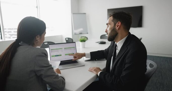 Two colleagues working together to analyze and making decisions engaged in collaborative discussion, celebrate success exchanging fist bump, gesture of productive teamwork and joint task finalizing
