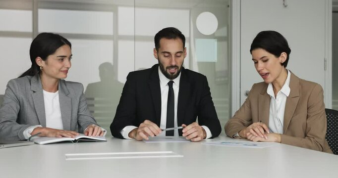 Professional employees talking seated at conference table, listening female teammate provide explanation, express solution and point, reviewing sales statistics, analyzing financial data in boardroom