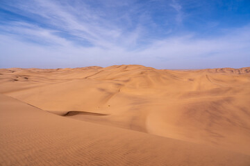 The towering dunes of Namibia stretch endlessly under the vast, clear sky