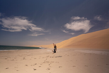The waves crash behind him as he takes in the magnificent desert, a true wonder of nature