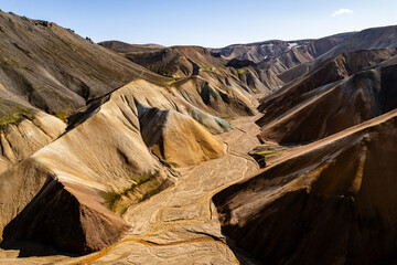 Vivid aerial view of colorful volcanic Landmannalaugar mountains and eroded terrain under clear sky, showcasing natural beauty and geological wonders. Perfect depiction for landscapes and travel