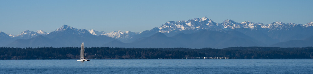 Cool blue winter landscape looking across Puget Sound with the Olympic Mountains in the background,...