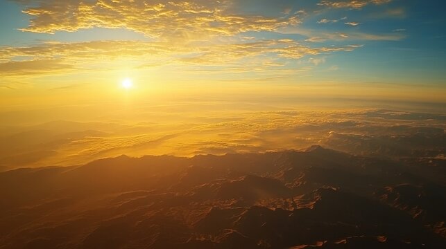 Aerial view of mountains and hills during golden sunset with blue skies and clouds