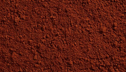Rich brown powdered spice texture spread on a flat surface in natural light