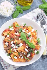 Rigatoni alla Norma pasta with eggplant, tomato, basil and ricotta salata, vertical top view