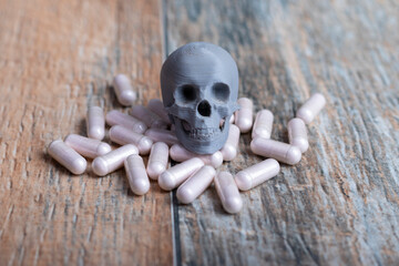 una calavera gris sobre un lote de cápsulas de fármacos