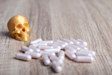 cápsulas de fármacos junto a una calavera amarilla