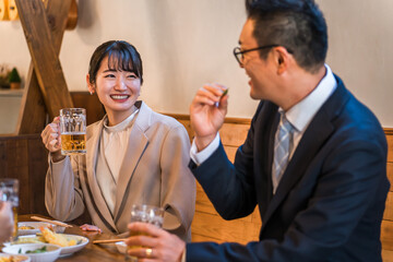 居酒屋・飲み屋で談笑する男女のサラリーマン
