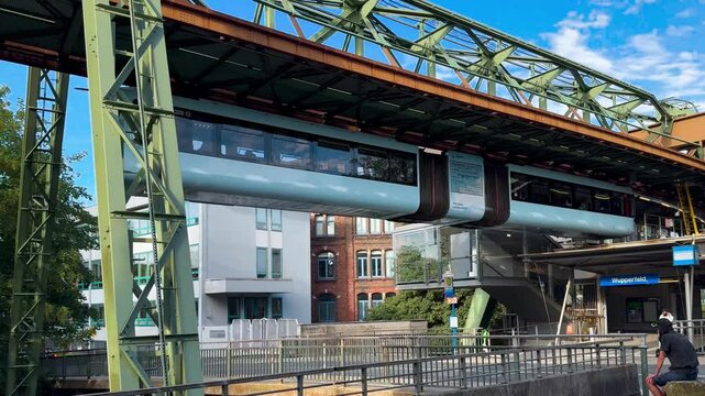 Train car moves on monorail suspended on overpass of Wuppertal Suspension Railway. Public transport metropolitan in Wuppertal, North Rhine Westphalia, Germany July 29, 2024. High quality 4k footage