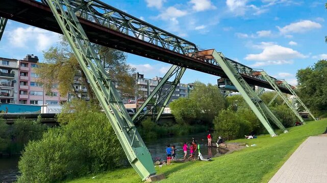 Train car moves on monorail suspended on overpass of Wuppertal Suspension Railway. Public transport metropolitan in Wuppertal, North Rhine Westphalia, Germany July 29, 2024. High quality 4k footage