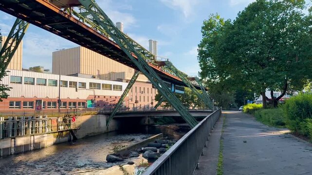 Train car moves on monorail suspended on overpass of Wuppertal Suspension Railway. Public transport metropolitan in Wuppertal, North Rhine Westphalia, Germany July 29, 2024. High quality 4k footage