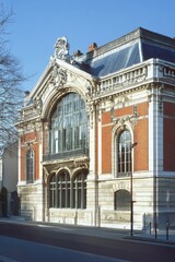 Obraz premium A magnificent historic building showcasing elegant architecture stands proudly in a vibrant urban setting, all under a brilliant, clear blue sky