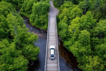 Fototapeta premium Scenic Aerial View of a White Car Driving on a Wood Bridge Surrounded by Lush Green Trees