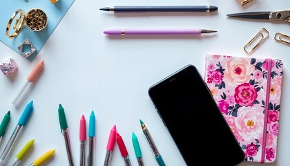 Naklejka premium Flat Lay Workspace with Pens, Phone and Floral Notebook on White