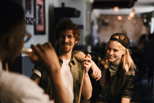 Friends playing pool and having fun together