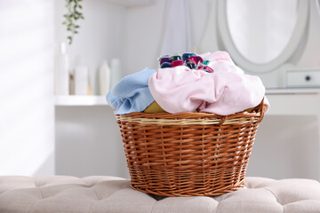 Laundry detergent and clothes in basket indoors