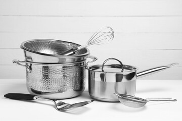 Dishware and cooking utensils on white table