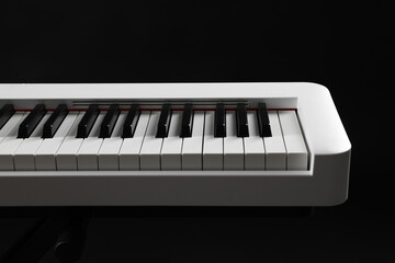 Synthesizer on black background, closeup. Electronic musical instrument