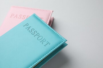 Passports in color covers on light background, closeup. Space for text