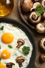 Tasty fried eggs with mushrooms and parsley served on table, flat lay
