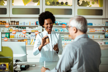 Friendly pharmacist helping a senior man with medicine