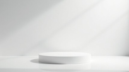 Simple white cylindrical pedestal in a minimalist studio setting with soft sunlight illuminating the scene