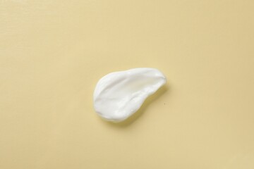 Smear of body cream on beige background, top view