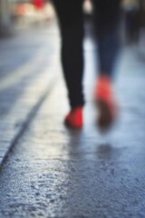 Fototapeta premium Blurry photo of a person walking on a wet street capturing the essence of urban movement and life : Generative AI