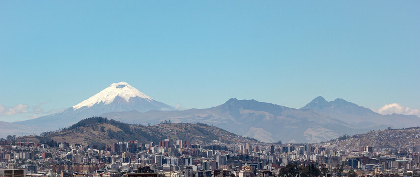 Vista panor&aacute;mica de Quito con el ic&oacute;nico Volc&aacute;n Cotopaxi de fondo, capturada desde la parte norte de la ciudad bajo un cielo despejado, Ecuador.