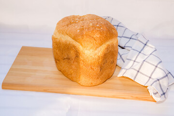 Fresh homemade bread on wooden cutting board.