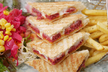 Delicious grilled sandwich with sides in a cozy cafe setting