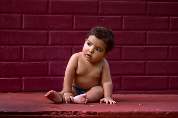 Baby sitting on the sidewalk, all dirty