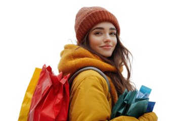 A cheerful young woman carrying colorful shopping bags on her back, dressed warmly in a stylish yellow coat and cozy knitted hat, exuding happiness.