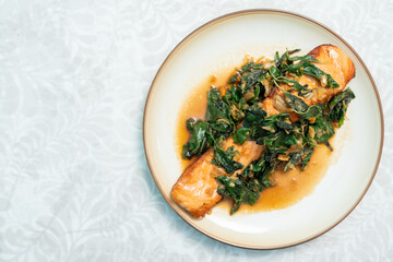 Fried fresh salmon topped with Pad Krapow. Salmon stir-fried with holy basil. Thai fusion food also known as kaprao salmon.