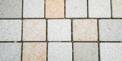Naklejka premium Detailed Close-Up View of a Patterned Paving Stone Surface Showing Subtle Color Variations and Small Plant Growth Between the Stones