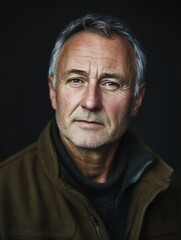 Obraz premium expressive mature man portrait against dark backdrop showcasing wisdom and character : Generative AI