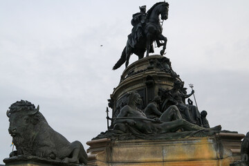 Equestrian statue stands tall in historic square during overcast day