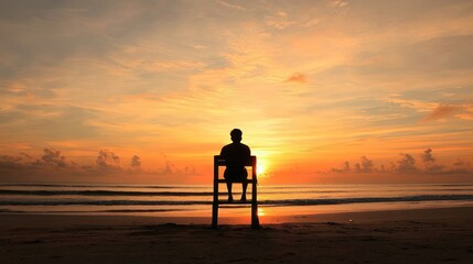 A serene sunset scene with a person sitting on a chair, gazing at the horizon over the ocean.