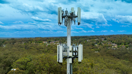 Drone aerial photograph of the top section of a telecommunications tower equipped with antennas and...