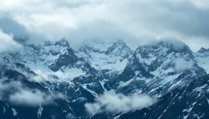 Fototapeta premium Majestic Snow-Capped Mountain Peaks Shrouded in Misty Clouds