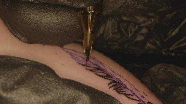 Closeup of Tattoo Being Drawn of a Feather on a Arm