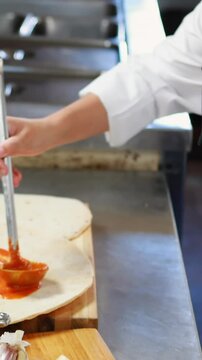 Chef applying sauce on flat bread