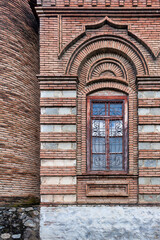 The stunning exterior of the Omar Efendi Mosque showcases the unique brickwork, arched window, and detailed design elements that reflect the architectural heritage of Shaki, Azerbaijan